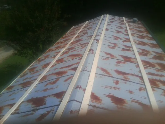 Rusted metal roof panels with new wood purlins before replacement in Dearing