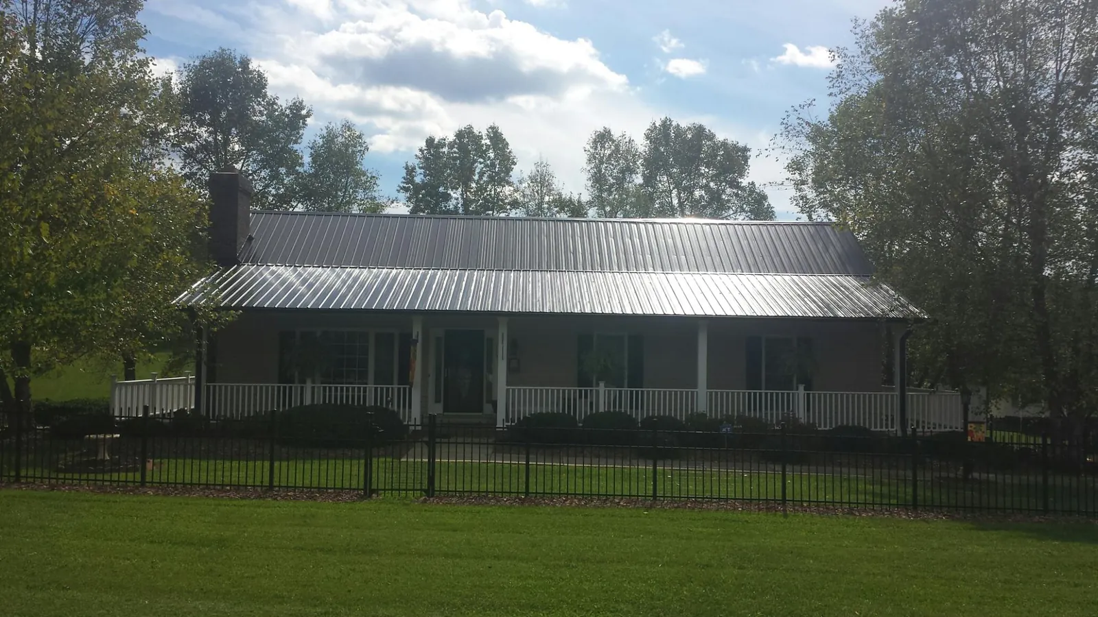Gray metal roof on a brick ranch with a full width front porch — Gutter Guard Installation work by our crew in Dearing
